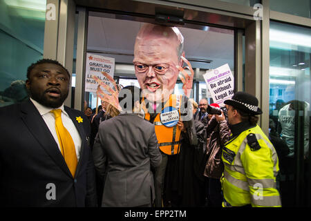 Polizei- und Sicherheitskräfte versuchen zu verhindern, dass eine Marionette des Justiz-Staatssekretär Chris Grayling in gezogen des Justizministeriums während einer Protestaktion von Anwälten gegen geplante Kürzungen auf Beratungs-/Prozesskostenhilfe. Stockfoto