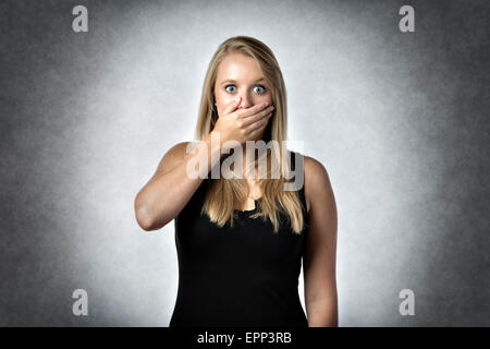 Blonde schockiert Frau ängstlich die Hand über den Mund hält Stockfoto