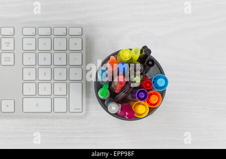 Container für Stifte und Marker, Fokus Top Container und Computer-Tastatur auf rustikale weiße Desktop. Stockfoto