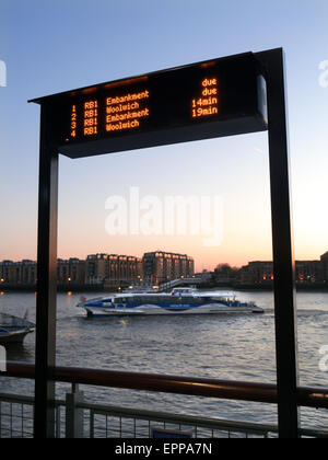 RIVER BOAT RB 1 Ankünfte Informationen Bildschirm und RB1 Thames Clipper Bootstour bei Sonnenuntergang am Canary Wharf London UK anreisen Stockfoto