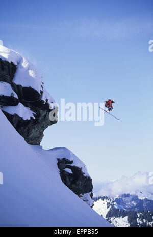 Man startet von einer Klippe auf seinen Skiern in Champéry, Schweiz Stockfoto