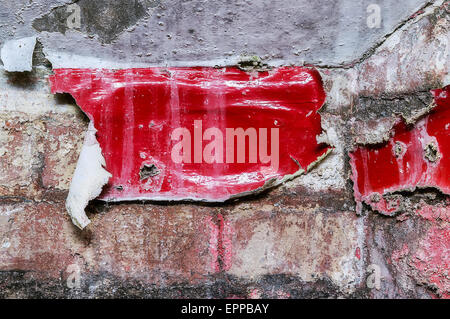 Detail einer alten Backstein-Mauer mit rot, alte Farbe bedeckt. Stockfoto