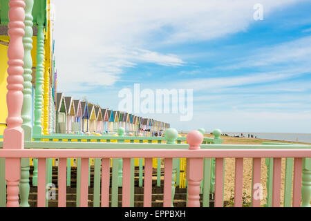 Eine Linie der hell farbigen Strandhütten an West Mersea, in der Nähe von Colchester, Essex UK Stockfoto