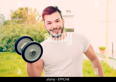 ein lächelnder junger Mann während seiner Fitness Übungen im freien warm Filter und Len Flare angewendet Stockfoto