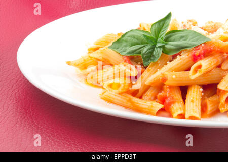 Lecker Wodka Penne garniert mit Basilikum Blätter Stockfoto