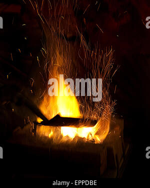 Schmiede Feuer Flamme Tipps mit Funken Closeup auf dunklem Hintergrund Stockfoto