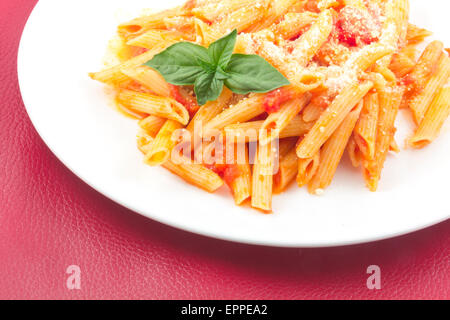 Lecker Wodka Penne garniert mit Basilikum Blätter Stockfoto