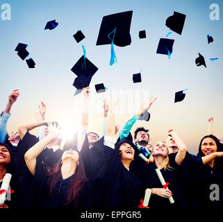 Fröhliche Schüler Abschluss Kappen in die Luft werfen Stockfoto