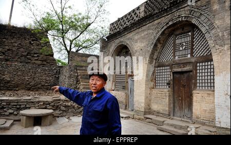 Zichang, chinesischen Provinz Shaanxi. 20. Mai 2015. Resident Guo Zhiying spricht über seine alte Hosue in Anding Stadt Zichang County, Nordwesten der chinesischen Provinz Shaanxi, 20. Mai 2015. Die 1.600-j hrige Anding Stadt hat gut erhaltene Zhongshan Mountain Grotten und andere Architekturen der Antike. © Tao Ming/Xinhua/Alamy Live-Nachrichten Stockfoto