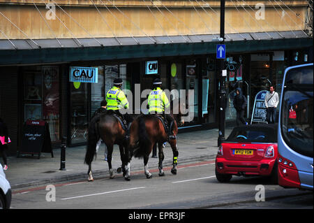 Zwei britische Polizisten patrouillieren einer Straße auf dem Pferderücken in Bristol. Stockfoto