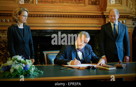 Hamburg, Deutschland. 21. Mai 2015. Estonian President Toomas Hendrik Ilves (C) macht einen Eintrag im Gästebuch der Stadt, während Bürgermeister von Hamburg Olaf Scholz und Carola Veit Legistlative Präsident der Versammlung im Rathaus in Hamburg, Deutschland, 21. Mai 2015 aussehen auf. Hamburg ist die letzte Station auf dem estnischen Präsidenten 4-Tage-Besuch in Deutschland. Foto: AXEL HEIMKEN/Dpa/Alamy Live News Stockfoto