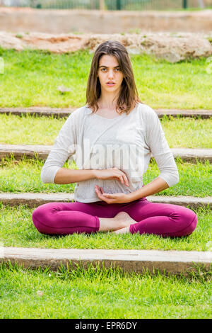 Junge Frau MakinYoung Frau machen ihre Yoga-Übungen im Park am Stairsg Yoga im Park Model release verfügbar Stockfoto