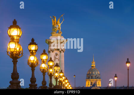 Reihe von Laternen entlang Pont Alexandre III mit Kuppel des Hotel des Invalides über Paris, Frankreich Stockfoto
