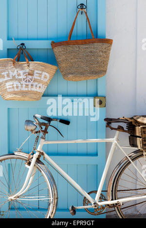 Altes Fahrrad blaue Tür gelehnt. Stockfoto
