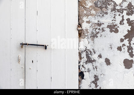 weiße Tür auf eine weiß getünchte Wand Stockfoto