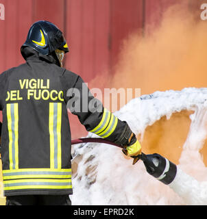 Feuerwehrleute in Aktion mit Schaum löschte das Feuer des Autos Stockfoto