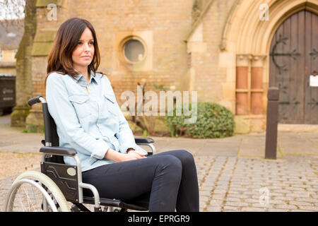 eine junge Frau in einem Rollstuhl schauen traurig Stockfoto