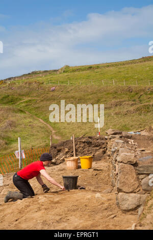 Aushubarbeiten in Whitesands Bay, Pembrokeshire Coast National Park, Wales, Großbritannien im Mai - Frau mit Kelle Aushub Stockfoto