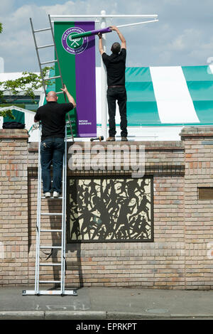 Arbeiter entfalten die Ehrenrolle Banner am AELTC auf 2014 WImbledon Tennis Turniersieger Novak Djokovic und Petra Kvitova Credit: Amer Ghazzal/Alamy Live-Nachrichten Stockfoto