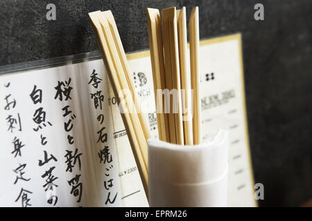 Speisekarte des Restaurants, Stäbchen aus Glas mit Servietten an Wand, Tokio, Japan. Stockfoto