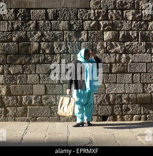 Asiatische Frau Tracht stehen in der Straße in der Sonne, in El Raval, Barcelona, Katalonien, Spanien. Stockfoto
