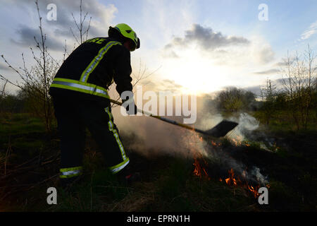 Ein Feuerwehrmann Außerbetriebnahme Flammen an einem Feld Feuer. Bild: Scott Bairstow/Alamy Stockfoto