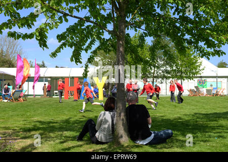 Hay-Festival, Powys, Wales - Eröffnungstag für 2015 Hay Festival bei strahlendem Sonnenschein. Ein paar zusehen, wie Schülerinnen und Schüler eine herumlaufen durch das riesige Heu Zeichen an Tag1 der Hay Festival genießen. Stockfoto