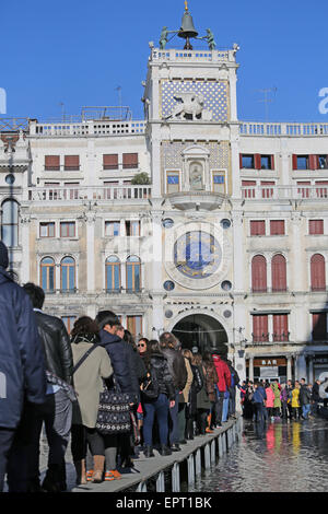 Venedig, VE, Italien - 31. Januar 2015: Touristen in Venedig Fuß auf dem erhöhten Gehweg an den hohen Gezeiten in den Markusplatz Stockfoto