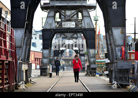 Fußgängerzone unter den erhaltenen Ladung Kräne entlang der Hafenpromenade in Bristol. Stockfoto