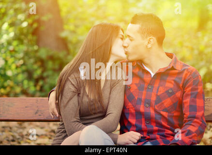 Paar Küssen auf der Bank im park Stockfoto