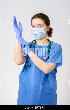 Ärztin, blaue OP-Handschuhe anziehen Stockfoto