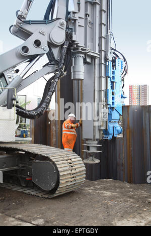 Eine große Anhäufung Rig benutzt eine "Stille" vibrierenden Kopf Stahl Spundwände an einem Flussufer London installieren Stockfoto