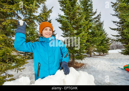 Junge bereit, Schneeball werfen, während Spiel Stockfoto