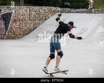 Junger Mann mit Schutzausrüstung beim Skateboarden in einem Skateboard-park Stockfoto