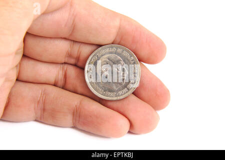 Kaukasischen Mann Hand hält eine alte spanische Münze 50 Peseten Franco Diktator Gesicht auf einem weißen Hintergrund angezeigt. 1957 Stockfoto