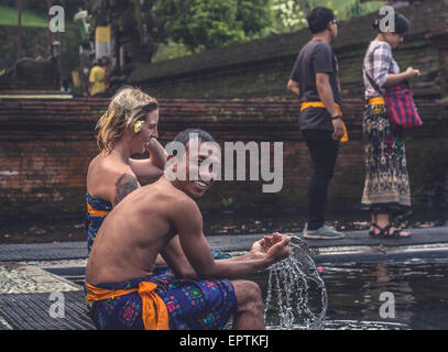 Bali, Indonesien - 21. Mai 2015: Hindus beten während der Reinigungszeremonie im Tirta Empul Tempel. Ausländer sind herzlich eingeladen, an der Zeremonie teilzunehmen. Stockfoto
