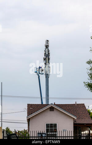 Zwei Männer arbeiten aus einem Aufzug Eimer auf einem Handy oder Handy Turm in Modesto, Kalifornien Stockfoto