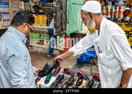 Mumbai Indien, Indischer Asiatisch, Dharavi, Shahu Nagar Road, Slum, niedriges Einkommen, arm, Armut, Erwachsene Erwachsene Erwachsene Männer Männer männlich, arbeitend, muslimisch, Männer, Schuhe, Verkauf, Verkauf, Kunde Stockfoto
