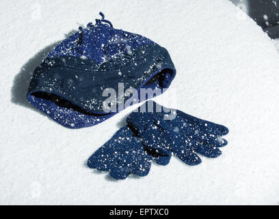 Eine gestrickte Mütze mit passenden Handschuhen im Schnee Stockfoto