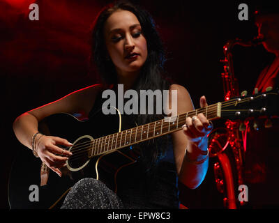 Schöne Frau spielt eine Gitarre, verrauchten Bühne auf Hintergrund Stockfoto