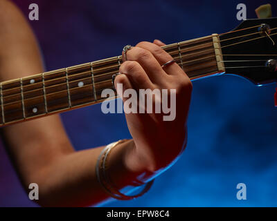 In der Nähe spielt, Frau eine Gitarre, verrauchten Bühne auf Hintergrund Stockfoto