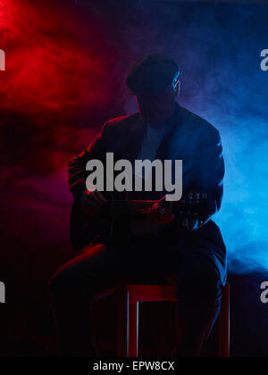 Reifer Mann spielt eine Gitarre, verrauchten Bühne auf Hintergrund Stockfoto