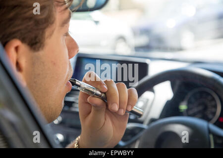 Junger Mann raucht Zigarette, whrend er Auto fhrt Stockfotografie - Alamy