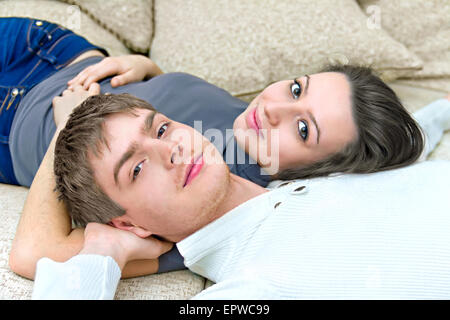 junger Mann und ein Mädchen auf der Couch liegen Stockfoto