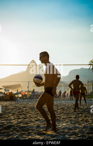 RIO DE JANEIRO, Brasilien - 1. Februar 2014: Junge Carioca Brasilianer spielen Sonnenuntergang Silhouette des Beach-Volleyball. Stockfoto