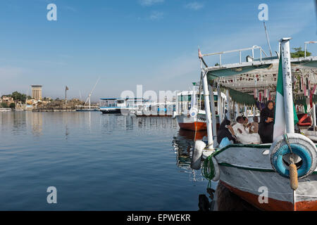 Menschen vor Ort wartet ein Wassertaxi zu segeln. Assuan, Oberägypten. Das Mövenpick Resort auf Kitchener Island ist im Hintergrund Stockfoto