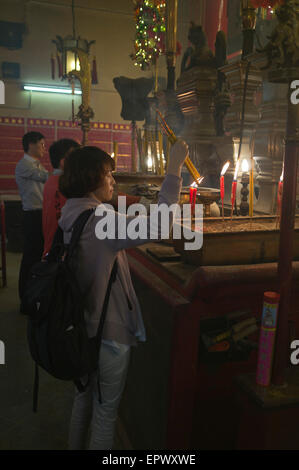 dh man Mo Temple SHEUNG WAN HONGKONG Chinesische Frau Joss Sticks Tempel Betende china taoismus Halten Sie Räucherstäbchen Menschen in sich Stockfoto