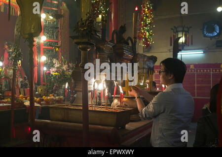 dh man Mo Temple SHEUNG WAN HONGKONG Chinese man lighting joss Sticks Tempel china Szene Tempel joss Stick tao Weihrauch Gebet brennend buddhist Stockfoto