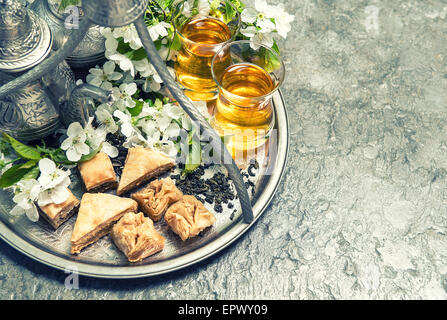 Tee Gläser und Topf, traditionelle Cookies Baklava. Islamische Feiertage Dekoration. Vintage-Stil getönten Bild Stockfoto