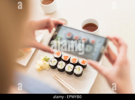 Frau fotografieren Sushi set Stockfoto